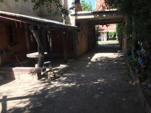 特拉皮切的住宿－Patio olmos，一条小巷,有一座建筑,在树荫下设有长凳