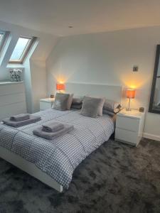 a bedroom with a large bed with two tables and two lamps at Airthrey Cottage in Bridge of Allan