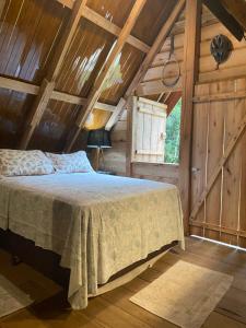 a bedroom with a bed in a wooden cabin at Chalé em meio à natureza! in Guabiruba