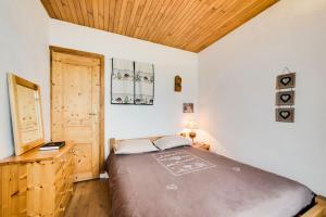 ein Schlafzimmer mit einem großen Bett und einer Holzdecke in der Unterkunft Situation unique a Val d'Isere ! in Val dʼIsère