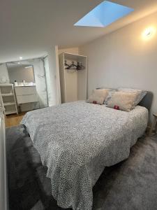 sypialnia z dużym łóżkiem i oknem w obiekcie Petite maison de ville avec mezzanine w mieście Ruelle-sur-Touvre
