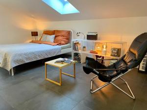 a bedroom with a bed and a chair and a table at Quiet, Central House (150sqm) with Garden & Sauna in Norderstedt