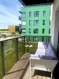 a balcony with a couch and a table and a building at Cozy one bedroom apartment in Tartu