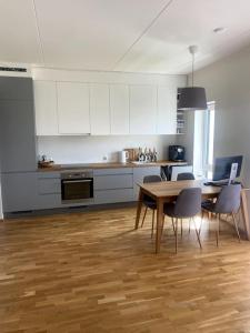 cocina con armarios blancos, mesa y sillas en Cozy one bedroom apartment, en Tartu