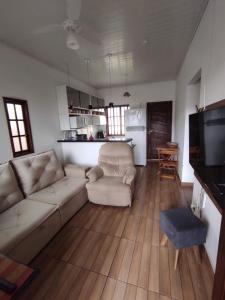 a living room with a couch and a tv at Casa 2 qtos, sendo suíte com cama Queen ar condicionado in Guapimirim