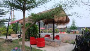 a pavilion with red chairs and a table at เช็คอินรีสอร์ท Check-in Resort in Chai Nat