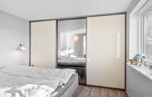 a bedroom with a sliding glass door with a bed at Beach Front Home In Fredericia With Wifi in Fredericia