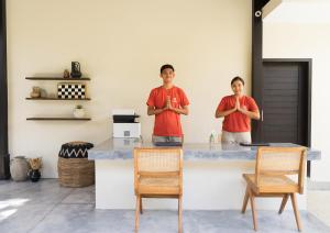 deux hommes debout dans une cuisine avec les bras croisés dans l'établissement Savanna Ubud, à Ubud