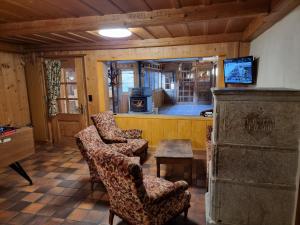 salon z 2 krzesłami i kuchenką w obiekcie Le Catogne w mieście Orsières