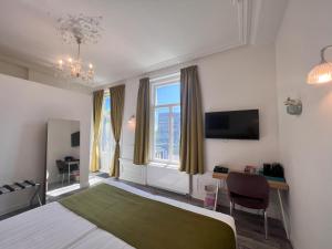 a bedroom with a bed and a tv and window at Hotel Loskade 45 in Middelburg