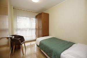 um quarto com uma cama, uma cadeira e uma janela em Apartamento céntrico en Girona em Girona