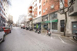 un groupe de motocycles garés dans une rue de la ville dans l'établissement Apartamento céntrico en Girona, à Gérone