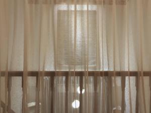 a black and white photo of a window with curtains at At corner resort & garden in Jeju +52 photos