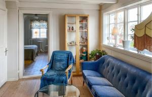 a living room with a blue couch and a glass table at 3 Bedroom Amazing Home In Borgholm in Borgholm