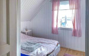 a bedroom with a bed and a window with pink curtains at 3 Bedroom Amazing Home In Borgholm in Borgholm