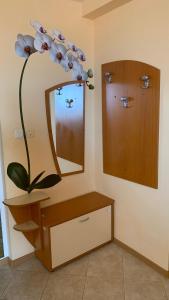 uma casa de banho com um espelho e uma flor na parede em Sunny Beach Hills Private Apartment em Sunny Beach