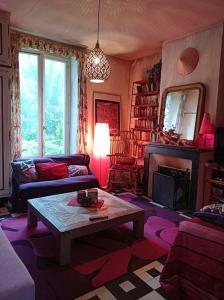 salon z kanapą i stołem w obiekcie Maison de campagne en cours de rénovation accessible en train w mieście Cravant