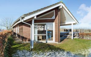 a small wooden house with a large window at Amazing Home In Sams With Wi-fi in Brundby
