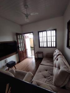 a living room with a couch and a flat screen tv at Casa 2 qtos, sendo suíte com cama Queen ar condicionado in Guapimirim