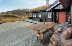 a wooden deck with a table on a house at Beautiful Home In Vringsfoss With House A Panoramic View in Maurset