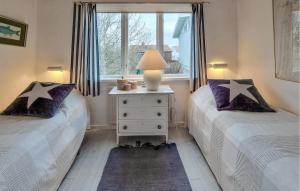 two twin beds in a room with a window at Lovely Home In Hönö With Harbor View in Hönö +2 photos