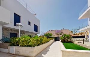 un patio de un edificio con césped verde en 2 Bedroom Awesome Apartment In Los Arenales Del Sol en Arenales del Sol