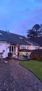 a white house with a fence and a yard at Airthrey Cottage in Bridge of Allan