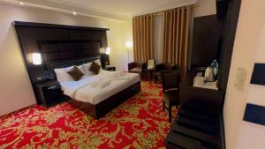 a hotel room with a large bed and a red carpet at Sparr Hotel in Amman +75 photos