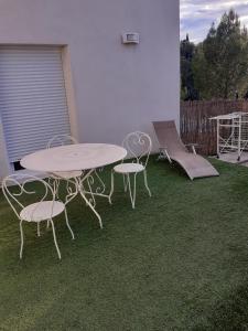 un tavolo e sedie su un patio con prato di La plaine a Saint-Clément-de-Rivière