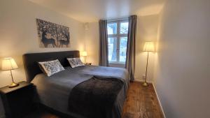 a bedroom with a bed with two lamps and a window at Beautiful lakefront house in Västerås