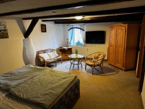 Schlafzimmer mit einem Bett, einem Tisch und einem TV in der Unterkunft Pension Zum Fäßchen in Naumburg