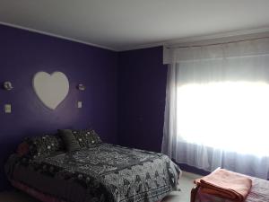 1 dormitorio con 1 cama con un corazón en la pared en Apart Dos Leones Temporario en Trelew