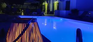 a swimming pool at night with blue lights at Frangiscos in Parikia