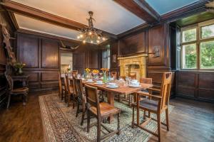 a dining room with a table and chairs and a fireplace at Gors-Y-Gedol in Dyffryn