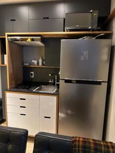 a kitchen with a stainless steel refrigerator and a microwave at Premium Studio 93 Tag Decor in Sao Paulo