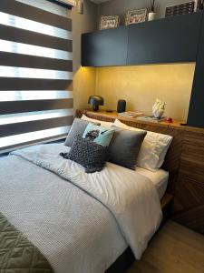 um quarto com uma cama com lençóis brancos e almofadas em Premium Studio 93 Tag Decor em São Paulo