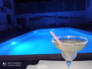 a drink in a glass next to a swimming pool at Frangiscos in Parikia