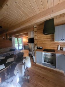 a living room of a log cabin with a kitchen at domek w zaczarowanym lesie in Istebna