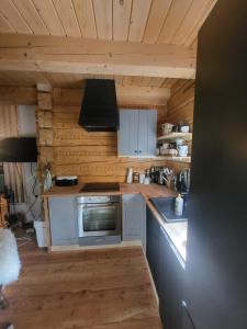 a kitchen with white cabinets and a stove top oven at domek w zaczarowanym lesie in Istebna