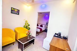 salon z żółtym krzesłem i łóżkiem w obiekcie ZIONS AIRPORT HOTEL w mieście Bengaluru