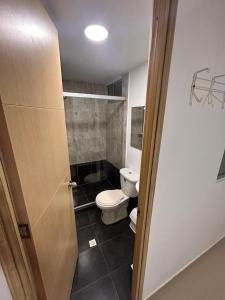 een kleine badkamer met een toilet en een deur bij Habitación Principal Con Baño Privado in Sabaneta