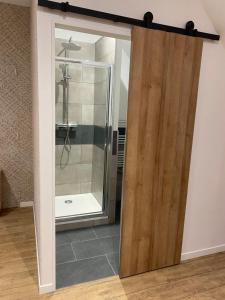 przesuwane szklane drzwi prowadzące do prysznica w łazience w obiekcie La petite Suite de La Jumelle w mieście Aire-sur-la-Lys