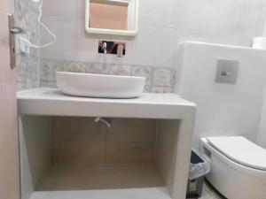 a bathroom with a white sink and a toilet at Sasa Estate in Fira