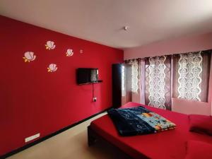 a red bedroom with a red wall with a red couch at Ooty Silver Wood Residency in Ooty