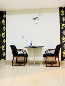 two chairs and a table in a room with a table at Highrise Apartments in Gujrānwāla