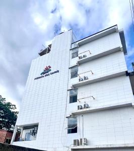 a white building with a sign on the side of it at Mirante dos Corais in Porto De Galinhas