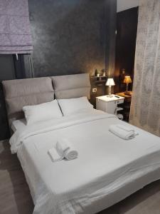 ein großes weißes Bett mit zwei Hausschuhen darüber in der Unterkunft Cozy home in Ioannina