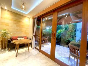 a living room with a glass door and a table at Ayu Homestay in Ubud