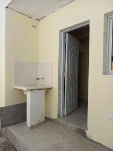 an open door to a room with a white wall and a table at Ferienhaus La Romana in La Romana