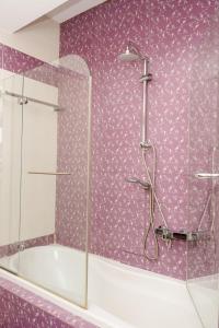 a purple bathroom with a shower and a tub at Cozy home in Ioannina